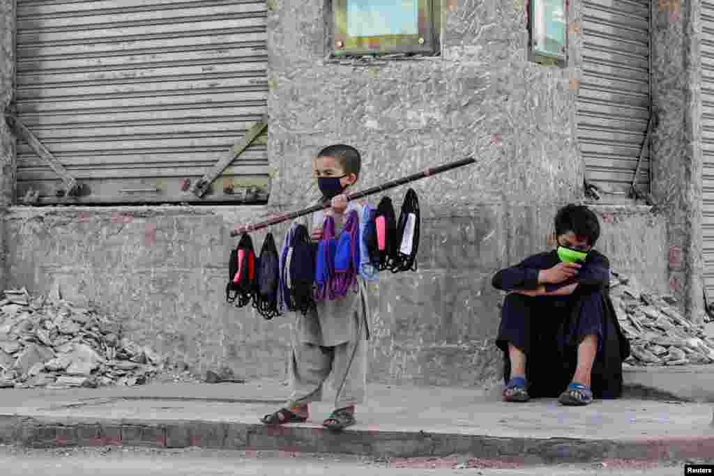 Seven-year-old Uzbillah sells face masks during a lockdown after Pakistan shut all markets, public places and discouraged large gatherings amid an outbreak of coronavirus disease (COVID-19).