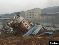 A damaged vehicle is seen among the debris at the site of a landslide at an industrial park in Shenzhen, Guangdong province, China, Dec. 20, 2015.