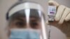 Seorang petugas medis mengisi jarum suntik dengan vaksin AstraZeneca, 16 Maret 2021. (Foto: REUTERS/Irakli Gedenidze)