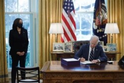 U.S. President Joe Biden signs the American Rescue Plan, a package of economic relief measures to respond to the impact of the coronavirus disease (COVID-19) pandemic, inside the Oval Office at the White House in Washington, U.S., March 11, 2021. REUTERS/