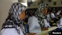 A migrant worker heading for Middle East countries holds her passport documents at an immigration office in Tangerang, Indonesia's Banten province, file photo. 