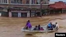 People ride a boat through flodwaters in Ba, Viti Levu, Fiji, in this still image taken from a social media video from April 1, 2018. (Courtesy - Sanjeet Ram)