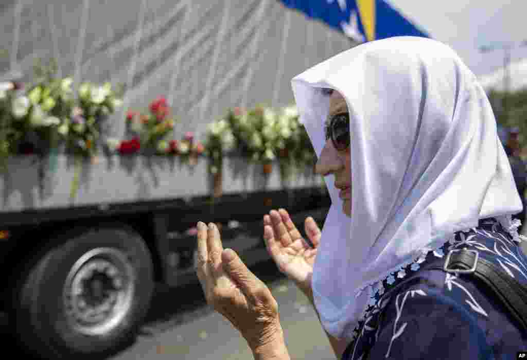 یک زن مسلمان در بوسنی، در کنار خودروی حامل بقایای اجساد حدود سی نفر از قربانیان نسل کشی مسلمانان بوسنی بیست سال پیش. حدود هشت هزار نفر توسط ارتش نیروهای صرب به قتل رسیده بودند. 