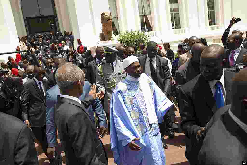 Senegal's outgoing President Abdoulaye Wade, center right, leaves the presidential palace, ceding its occupancy to newly inaugurated leader Macky Sall, in Dakar, Senegal Monday, April 2, 2012. Sall took the oath of office Monday in a ceremony held one wee