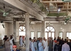 Warga dan petugas penyelamat berkumpul di lokasi ledakan bom di sebuah madrasah di Peshawar, Pakistan, 27 Oktober 2020. (Foto: REUTERS/Fayaz Aziz)