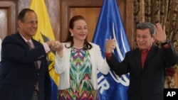 Ecuador's Foreign Minister Fernanda Espinosa stands between ELN rebel leader Pablo Beltran, right, and Colombia's government representative Juan Camilo Restrepo at the end of a press conference announcing the signing of a cease-fire in Quito, Ecuador, Sept. 4, 2017.