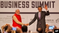 U.S. President Barack Obama, right waves to the audience as he and Indian Prime Minister Narendra Modi attend the India-U.S business summit in New Delhi, India, Jan. 26, 2015. 