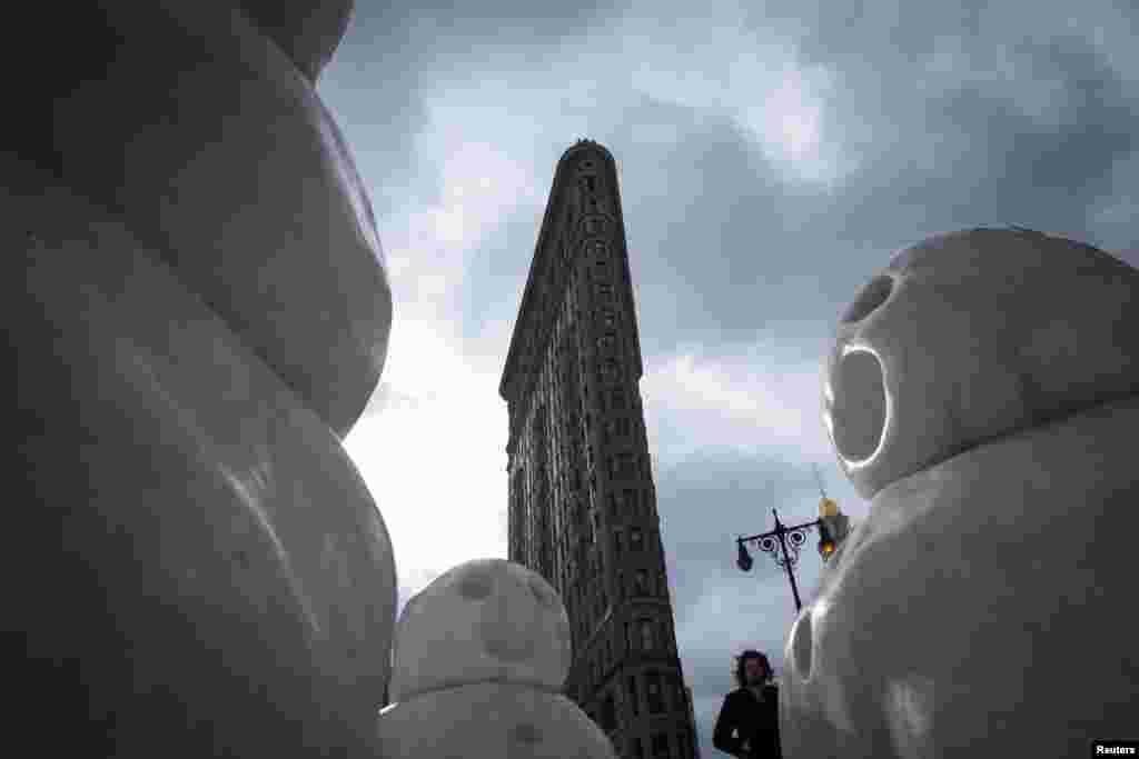 A man walks by artist Peter Regli's sculpture "Reality Hacking No 320 Snow Monsters" near the Flatiron Building in New York. 