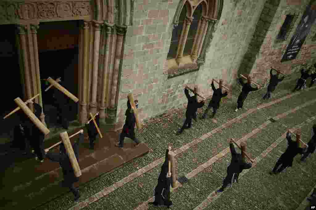 Masked penitents hold their crosses as they arrive at Roncesvalles Church during spring &quot;Romeria Cruceros de Arce&quot;, in northern Spain.