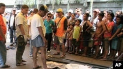 People look at bodies of flash floods victims in Davao city in southern Philippines June 29, 2011.