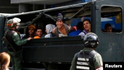 Estudiantes antigubernamentales gritan desde un camión luego de ser detenidos por la Guardia Nacional, tras una protesta en Caracas.