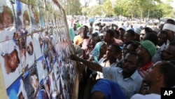 Relatives jostle to identify the bodies of their relatives who perished in a ferry tragedy that occurred on its way to Pemba on a picture board at the Maisara grounds in Zanzibar, September 11, 2011.