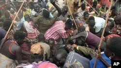 Villagers from Dadinga tribe struggle to get food after World Food Program staff distributed supplies in the village of Lauro in Eastern Equatoria State, South Sudan, April 2, 2010. 