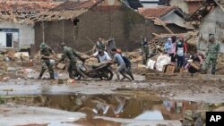 Rescuers pull a motorbike through the mud at a village badly hit by flash flood in Garut, West Java, Indonesia, Sept. 22, 2016. 