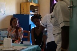 Medical workers examine mothers at Achikondi Community Clinic in Lilongwe, Malawi. (Lameck Masina/VOA)