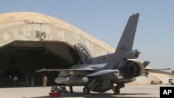 FILE - This July 2015 file photo shows one of four new U.S.- made F-16 fighter jets outside a hardened hangar upon its arrival to Balad air base, north of Baghdad, Iraq. 