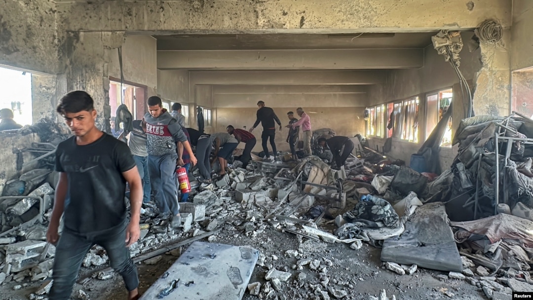 Palestinians inspect the site of an Israeli strike on a school sheltering displaced people, amid the Israel-Hamas conflict, in Nuseirat in the central Gaza Strip, Oct. 24, 2024.