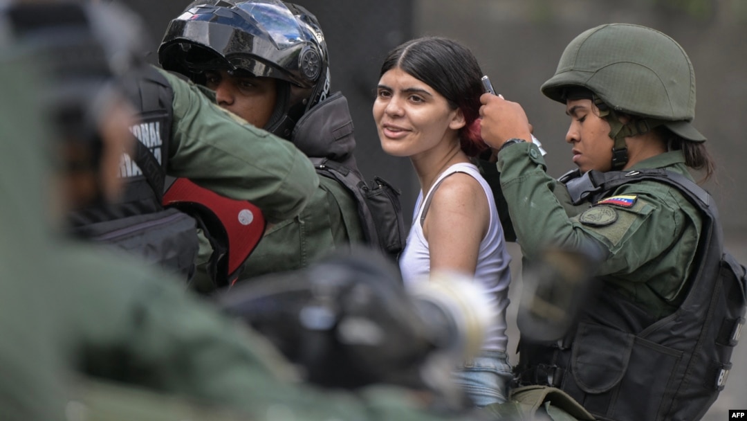 Militares de la Guardia Nacional venezolana detienen a una joven durante protestas contra el resultado de la elección presidencial, en Caracas, el 30 de julio de 2024.