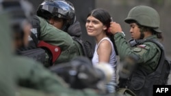 Militares de la Guardia Nacional venezolana detienen a una joven durante protestas contra el resultado de la elección presidencial, en Caracas, el 30 de julio de 2024.