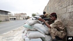 Yemeni army soldiers man a security point near a square, the site of an anti-government protest to demand the ouster of Yemen's President Ali Abdullah Saleh, in Sanaa May 25, 2011