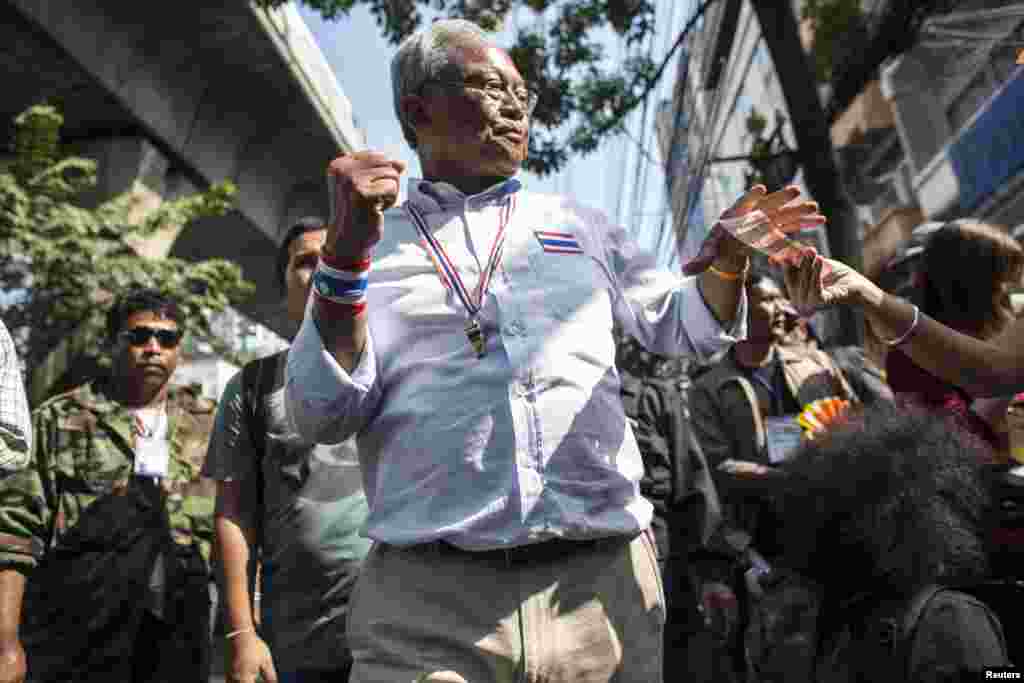 Protest leader Suthep Thaugsuban gestures as he collects money from a supporter during a rally in central Bangkok, Jan. 30, 2014. 