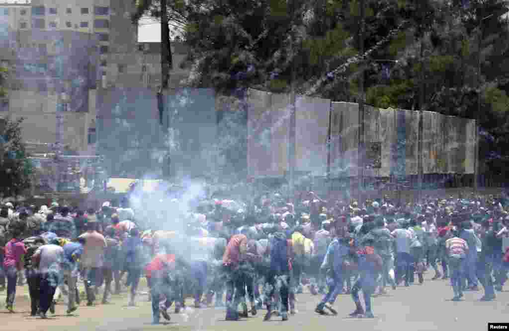 Supporters of Egypt&#39;s former President Mohamed Morsi run from tear gas during clashes with police in Cairo.