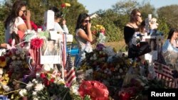 Well-wishers place mementos as students and parents arrive for voluntary campus orientation at the Marjory Stoneman Douglas High School, for the coming Wednesday's reopening, following last week's mass shooting in Parkland, Florida, Feb. 25, 2018.