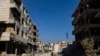 Women walk past destroyed buildings in the city of Harasta in Eastern Ghouta on the outskirts of Damascus, Dec. 15, 2024.