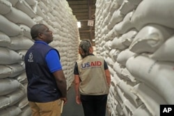 FILE - Officials from USAID and WFP inspect a donation of $11 million worth of food aid in Harare, Zimbabwe, Jan 17. 2024.