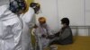 Un médico revisa los signos vitales de una anciana luego de ser inoculada con una dosis de la vacuna Pfizer COVID-19 como parte del período de observación, en el centro de convenciones convertido en sitio de vacunación, en Quito, Ecuador, el 31 de marzo. 