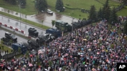 Belarusian opposition supporters gather in front of police line towards the Independence Palace, residence of the President Alexander Lukashenko in Minsk, Belarus, Aug. 30, 2020.