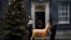 Two young women carry a model reindeer past 10 Downing Street in London, Britain.