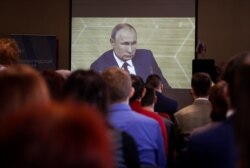 People watch a broadcast of Russian President Vladimir Putin's annual end-of-year news conference, in a library in Kaliningrad, Russia, Dec. 19, 2019.