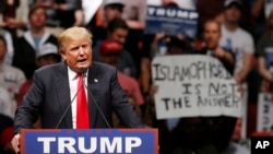 FILE - Republican presidential candidate Donald Trump speaks at a rally as a man holds up a sign that reads "Islamophobia is not the answer" in Oklahoma City, Oklahoma, Feb. 26, 2016. Amnesty International has called on Trump to uphold "the human rights of all without discrimination."