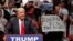 FILE - Republican presidential candidate Donald Trump speaks at a rally as a man holds up a sign that reads "Islamophobia is not the answer" in Oklahoma City, Feb. 26, 2016.
