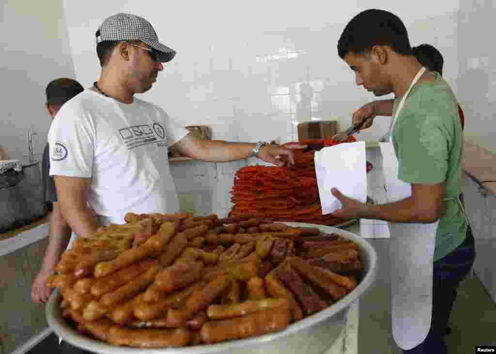 Tripolida mahalliy aholi iftor vaqtida shirinlikni ko&#39;p iste&#39;mol qiladi. Tripoli, 21-iyul, 2012-yil.