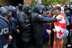 Gürcistan'ın başkenti Tiflis'te süren protestolarda, polis parlamento binasına giden yolu kapatarak, göstericilerin geçişine izin vermiyor- 13 Mayıs 2024.