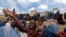 Displaced Afghans wait for aid near the site of a landslide at the Argo district in Badakhshan province.