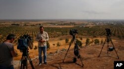 Beberapa wartawan televisi bersiap siaran di Ceylanpinar, Provinsi Sanliurfa, tenggara Turki, 20 Oktober 2019. 