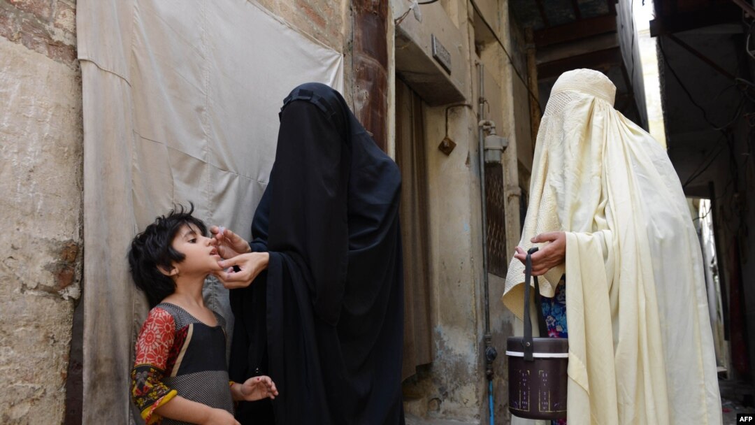 Para petugas kesehatan Pakistan memberikan vaksinasi polio pada seorang anak di Bannu.
