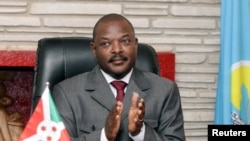 FILE - Burundi President Pierre Nkurunziza claps after signing the new constitution at the Presidential Palace in Gitega Province, June 7, 2018.