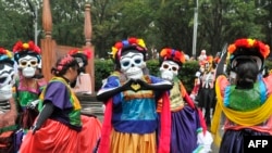 People take part in the Day of the Dead parade along Reforma avenue in Mexico City, on October 27, 2019. 