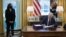 U.S. President Joe Biden signs the American Rescue Plan, a measure to respond to the impact of the coronavirus pandemic, inside the Oval Office at the White House in Washington, U.S., March 11, 2021. Standing at left is Vice President Kamala Harris. (REUTERS/Tom Brenner)