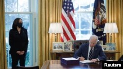 Wakil Presiden AS Kamala Harris mendampingi Presiden Joe Biden menandatangani paket bantuan untuk meredam imbas pandemi COVID-19 di Oval Office, Gedung Putih, Washington, 11 Maret 2021.