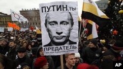 Opposition supporters hold a rally to protest against violations at the parliamentary elections and the policies conducted by current Russian authorities in St. Petersburg. The sign reads, "Putin, you are the traitor," December 18, 2011.