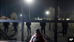 A child stands at the border line between Serbia and Hungary in Kelebija, Serbia, Feb. 6, 2020, where about two hundred migrants, gathered at Serbia's border with Hungary to demand to be allowed entry into the European Union country.