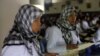 A migrant worker heading for Middle East countries holds her passport documents at an immigration office in Tangerang, Indonesia's Banten province, file photo. 