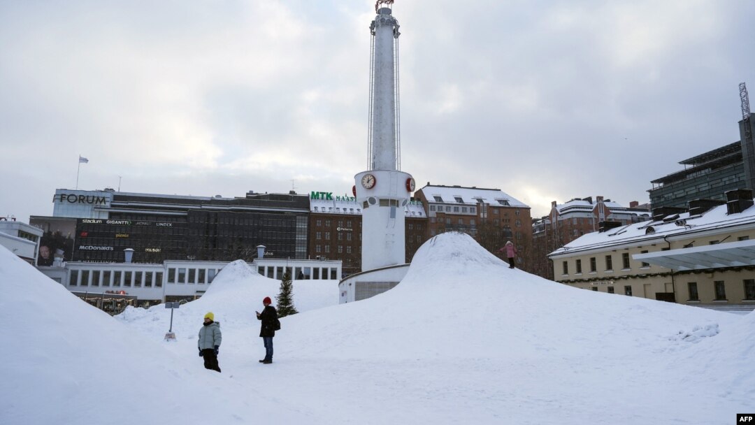 Ljudi stoje u snijegu u glavnom gradu Finske, Helsinkiju, 3. januara 2024. godine.
