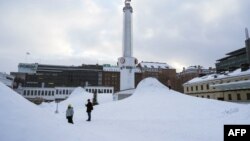 Ljudi stoje u snijegu u glavnom gradu Finske, Helsinkiju, 3. januara 2024. godine.