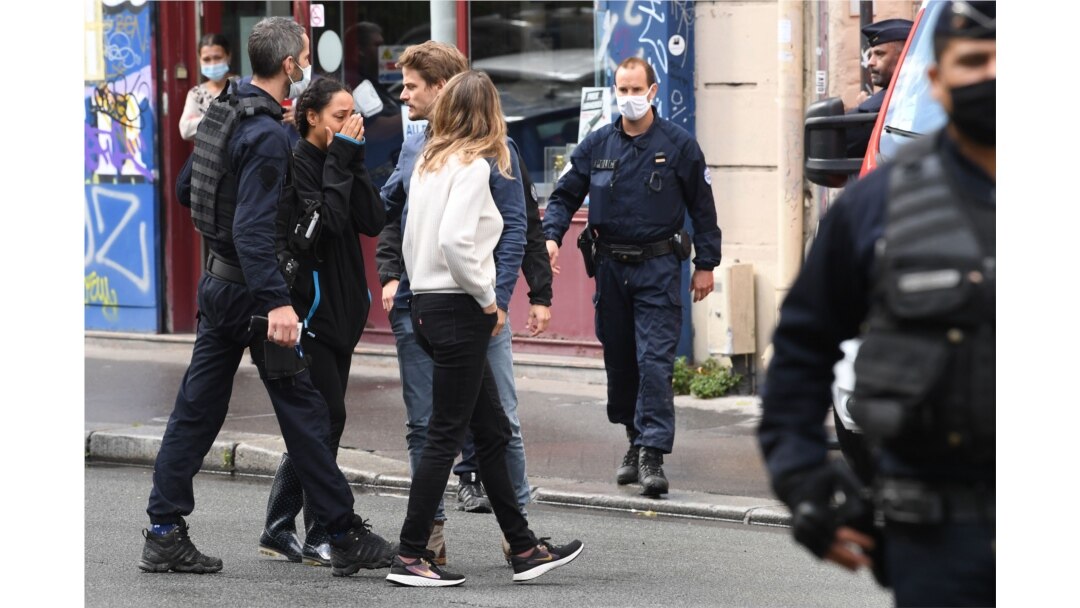 A woman reacts after several people were injured near the former offices of the French satirical magazine 'Charlie Hebdo' following an attack by a man wielding a knife in Paris, Sept. 25, 2020.